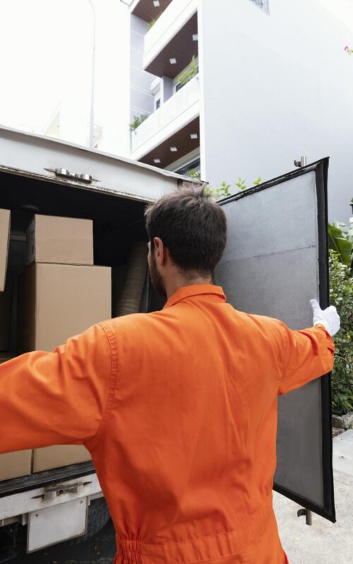 repartidor-joven-cerrando-las-puertas-del-camion-de-reparto-min